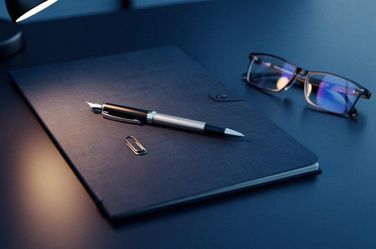 Un stylo plume posé sur un contrat signé, une paire de lunettes à côté